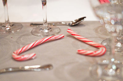 High angle view of candy cane with glasses and spoons on table