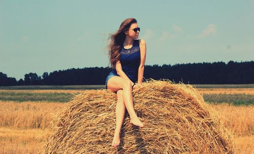 Portrait of young woman on hay bale