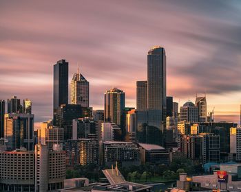 View of cityscape against cloudy sky during sunset