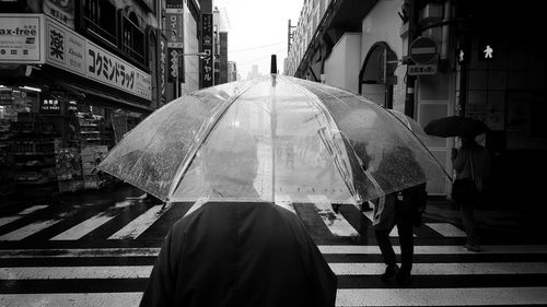 Rear view of people walking on city street