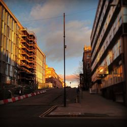 View of city street against cloudy sky