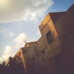 Low angle view of building against cloudy sky