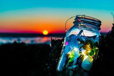 Close-up of lights in jar during sunset