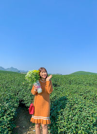 Portrait of man standing on field against clear sky