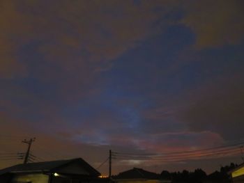 Low angle view of silhouette houses against sky during sunset