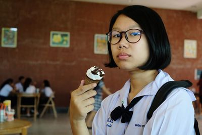 Portrait of smiling girl eating ice cream at school