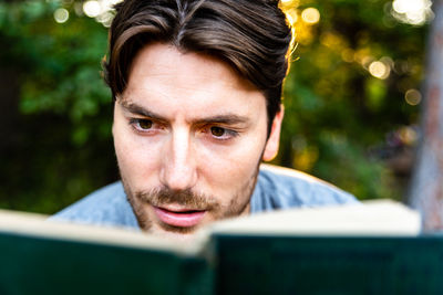 Close-up of man reading book