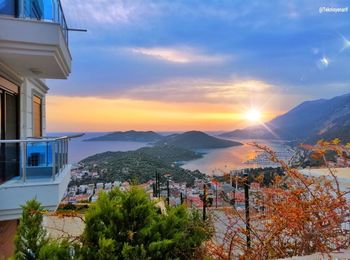 Scenic view of sea and buildings against sky during sunset