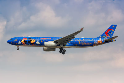 Low angle view of airplane flying against sky