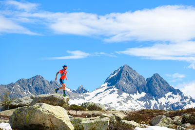 Rear view of man standing on mountain against sky