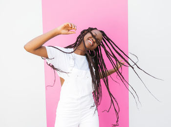 Portrait of young woman standing against white background