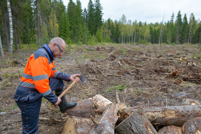 Side view of man working in forest