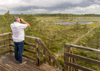 Rear view of man standing on railing