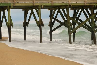 View of pier on beach against sky