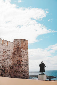 Rear view of tower against cloudy sky