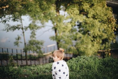 Rear view of boy looking at plants