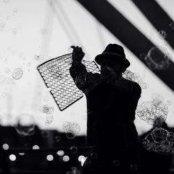 Silhouette of man making soap bubbles