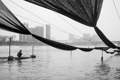 Man fishing in sea against clear sky