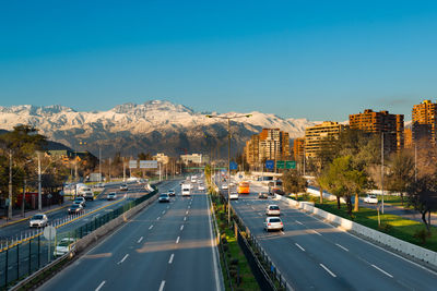 Cars on road by city against sky