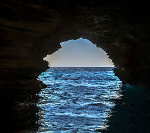 Scenic view of sea seen through cave