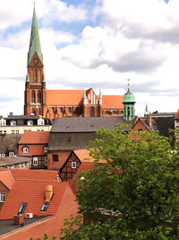 Buildings in city against cloudy sky