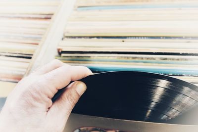 Cropped hand of man removing record from box