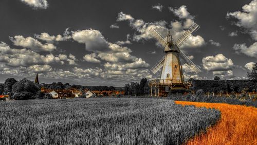 Traditional windmill on field against sky