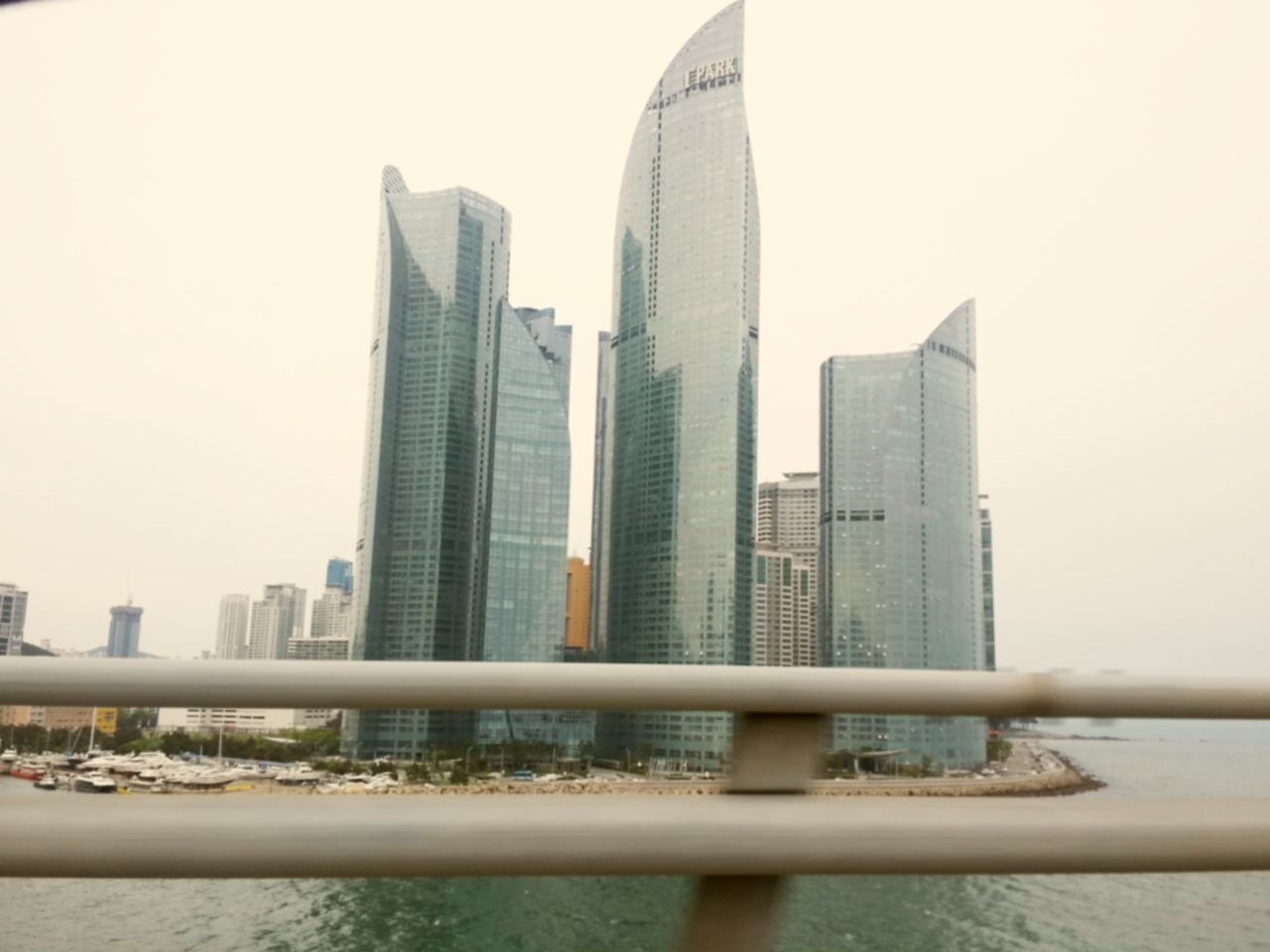 architecture, skyscraper, building exterior, built structure, city, modern, office building, tall - high, clear sky, tower, tall, urban skyline, sky, building, financial district, cityscape, day, railing, glass - material, low angle view