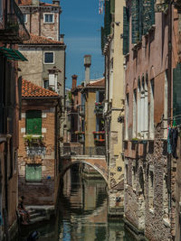 Bridge over canal amidst buildings in city