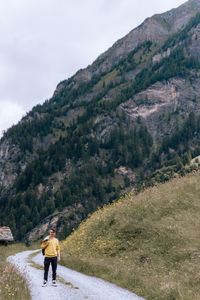 Rear view of man walking on mountain road