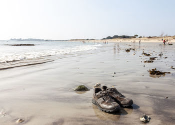 High angle view of shoes on beach against clear sky