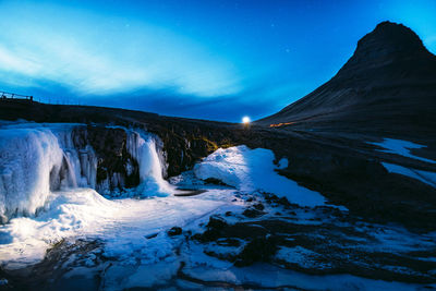 Scenic view of waterfall against sky during winter