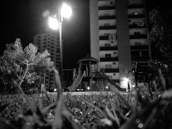 Illuminated street light against sky at night