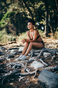 Young woman sitting in forest