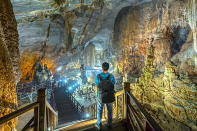 Rear view of man standing in cave