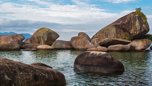 Rocks in sea against sky