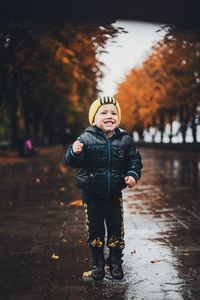 Portrait of boy standing in park during autumn