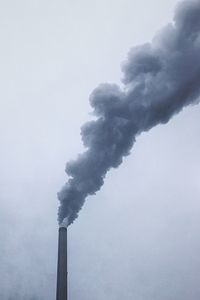 Smoke emitting from chimney against clear sky