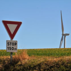 Information sign on field against clear sky