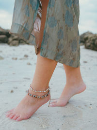 Low section of woman standing on beach