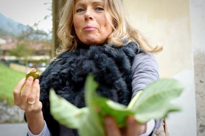 Close-up of leaves held by mature woman