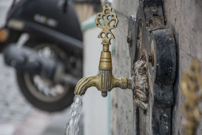 An old yellow faucet and running water