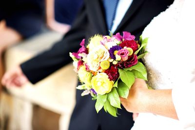 Close-up of hand holding bouquet of red rose