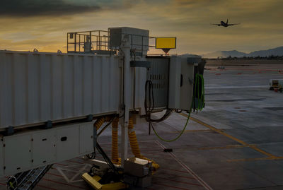 Airplane at airport against sky during sunset