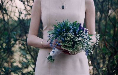 Midsection of woman holding flower bouquet