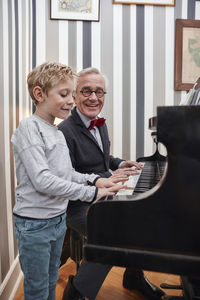 Grandfather and grandson playing piano together