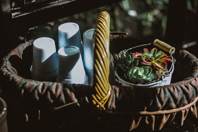 High angle view of succulent plant with drinking glasses in basket