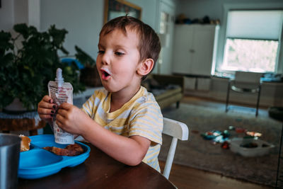 Boy sitting on table at home