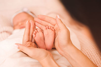 Mother holding legs of baby