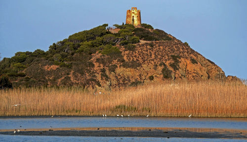 Scenic view of sea and hill against clear sky